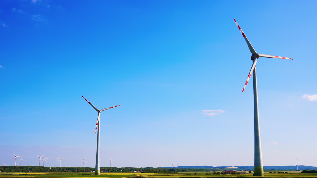 Wind turbines spinning in clear skies. Wind turbines generate renewable energy under a bright blue sky in an open landscape, showcasing sustainable technology