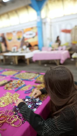 people shopping at a craft market, browsing handmade jewelry