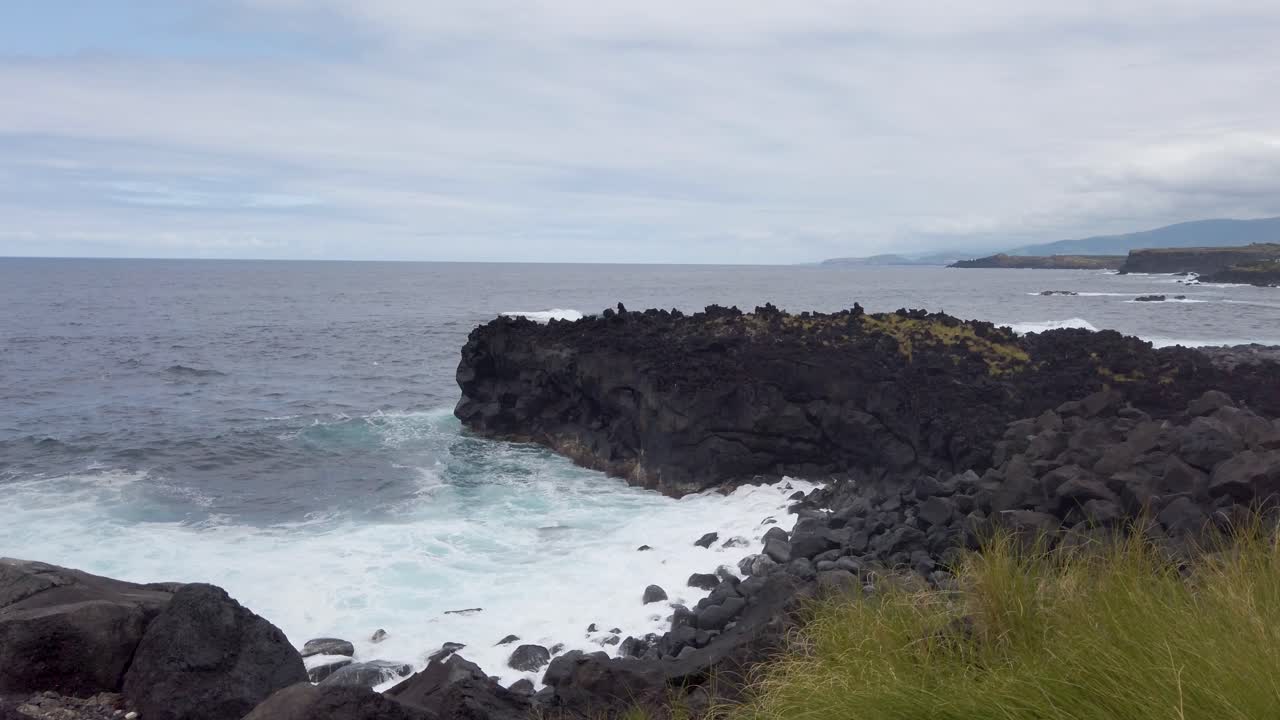 포르투갈 아조레스 제도 산 미구엘 섬의 카펠라스 해안의 화산 암석에 부 ⁇ 히는 파도 - 느린 동작 영상
