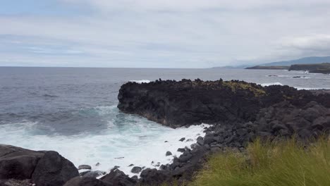 olas que golpean las rocas volcánicas en la costa de capelas, isla de san miguel de las azores, portugal - imágenes en cámara lenta