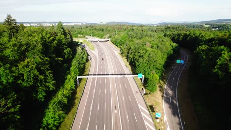 Cool-aerial-follow-shot-of-highway-traffic-through-lush-green-forests,-4K