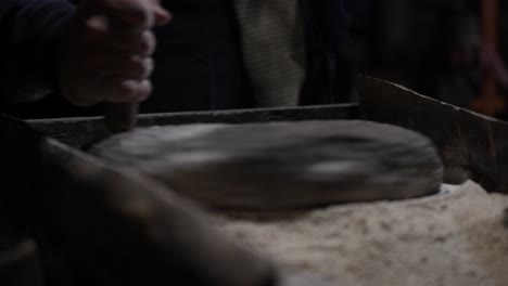 artisanal milling: hand-turned millstone grinds wheat, craftsmanship, and human ingenuity in traditional stone milling process for flour production