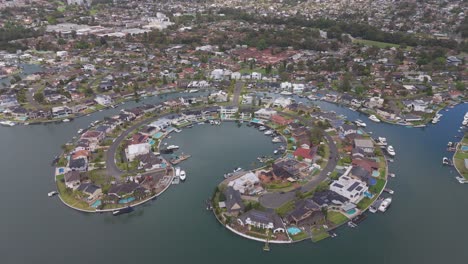 stunning aerial pull-back shot revealing luxury residential properties on james cook island, sylvania waters, sydney, nsw, with breathtaking waterfront views and coastal surroundings.