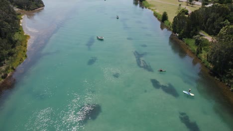 An-aerial-shot-overlooking-boats-and-swimmers-in-the-channel-at-The-Entrance-North,-NSW,-Australia