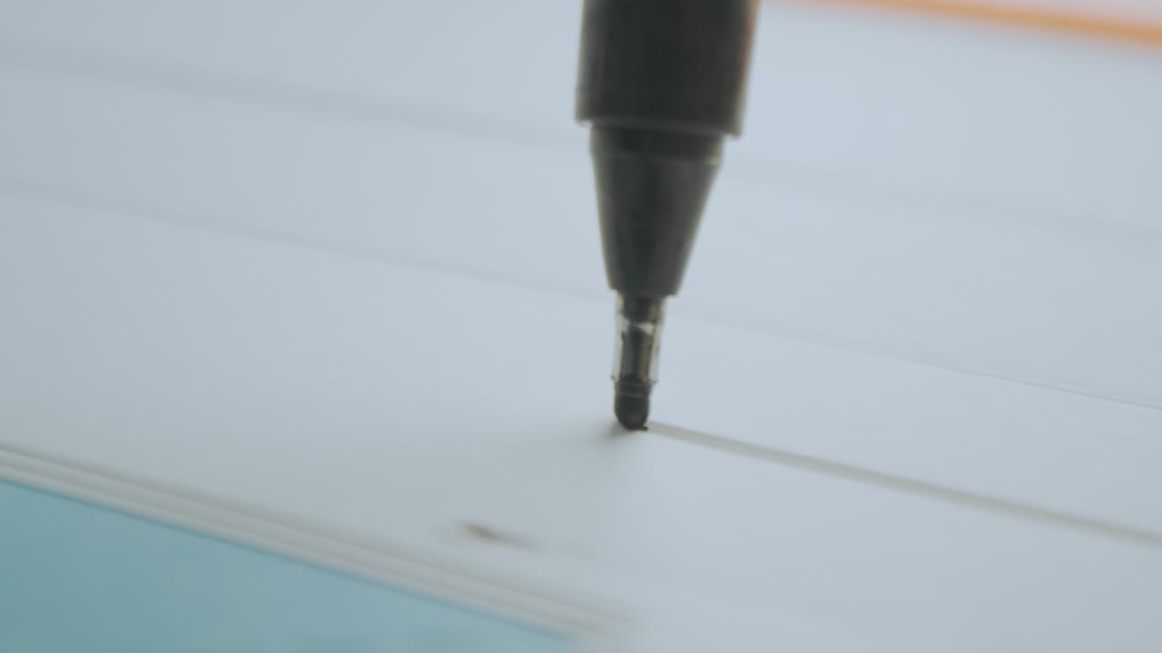 Close-up of a pen writing on gridded paper