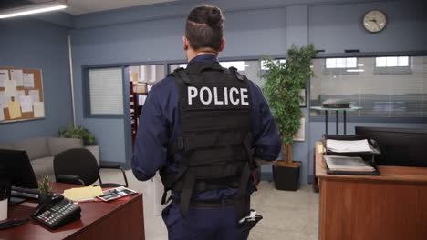 oficial de policía caminando por la oficina con una caja de archivos