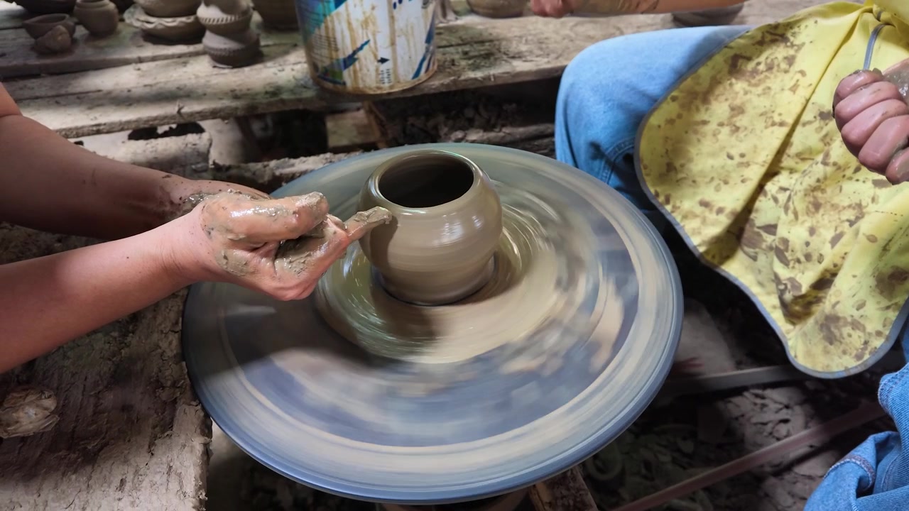 Primo piano di mani che modellano argilla bagnata su un tornio a Koh Kret, Thailandia