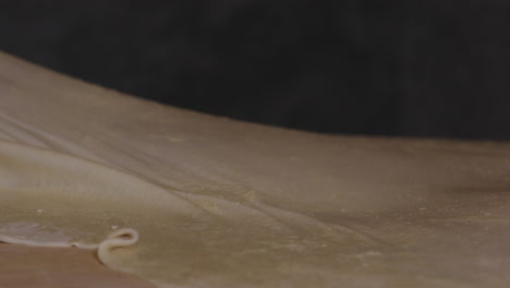 Woman-Spreading-Flat-Thin-Dough-For-Khinkali-Georgian-Dumplings---close-up