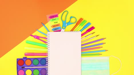 school stationery appear above open notebook. covid-19 back to school stop motion