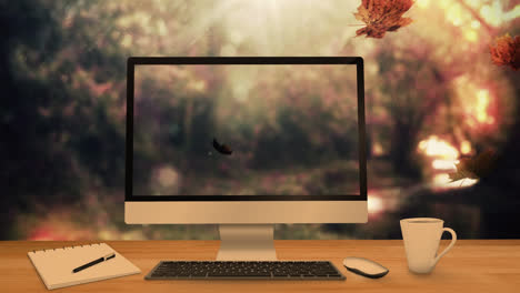 desktop computer and office equipment on a table against autumn maples leaves falling in background