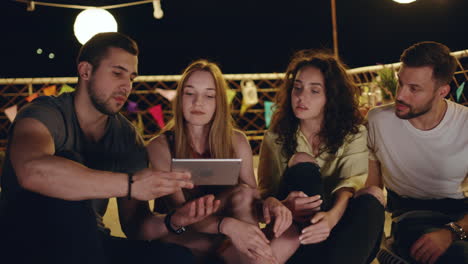 amigos reunidos alrededor de una tableta en