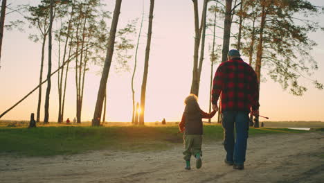 old man and his grandson are going to river for fishing granddad and child are spending weekend together