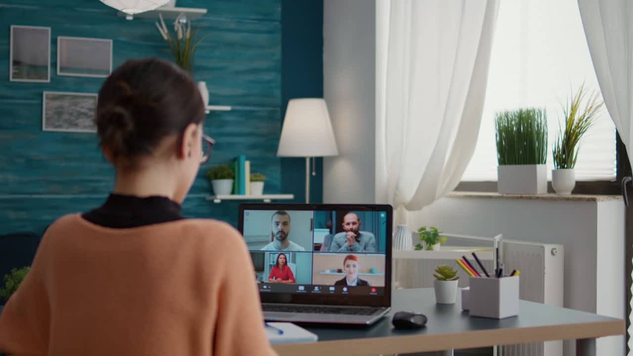 Young adult using online teleconference on laptop to attend online class