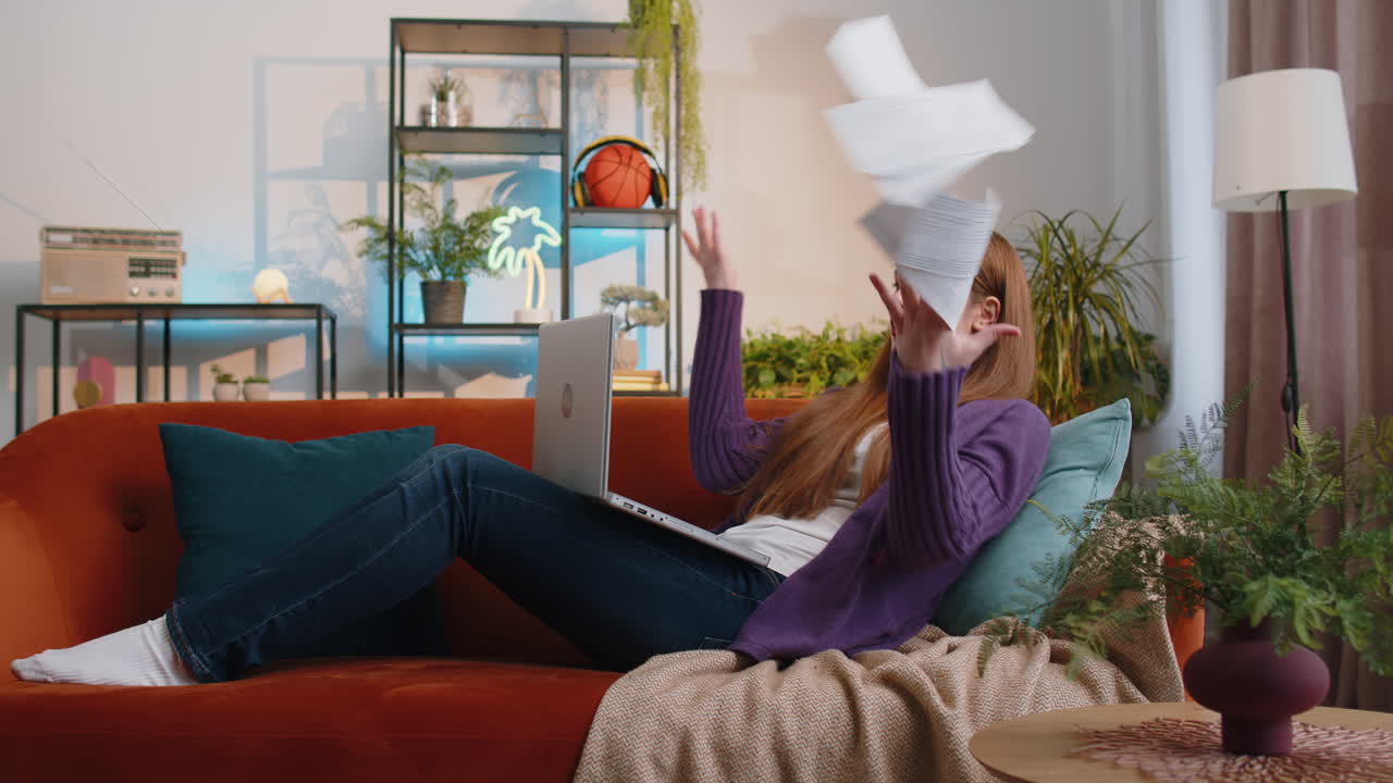 Stressed young woman looking at unpaid bank debt loan doing paperwork planning budget throws bills