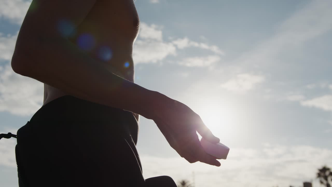 Surfer man walking to the beach at sunset preparing for surfing training and search for waves in Barcelona, spain, water, ocean exercise in sea with board, athletic male holiday or travel in vacation