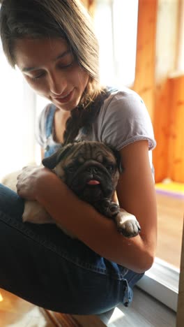 teenager hugging a puppy pug