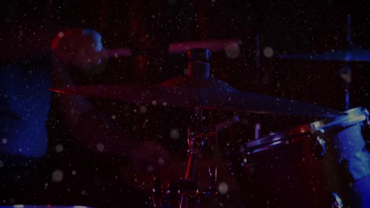 Rendering 3D che mostra un piatto di batteria che si illumina sotto luci rosso-blu e una bacchetta che fluttua sopra polvere sospesa.