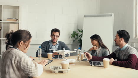 Group-of-young-hipsters-discussing-drone-technology