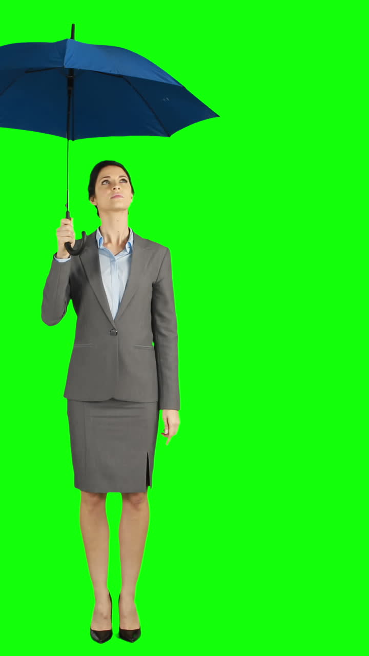 mujer de negocios de pie bajo un paraguas