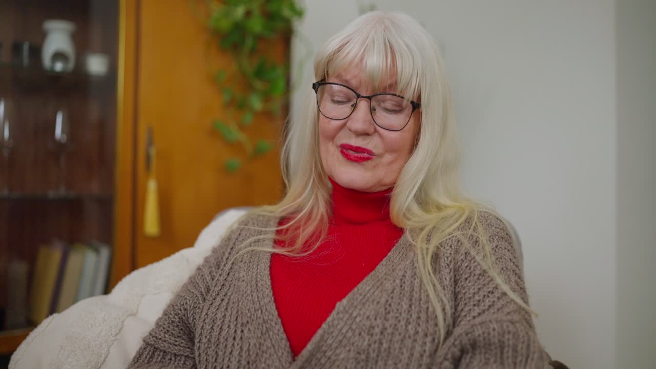 Senior donna che legge un libro a casa