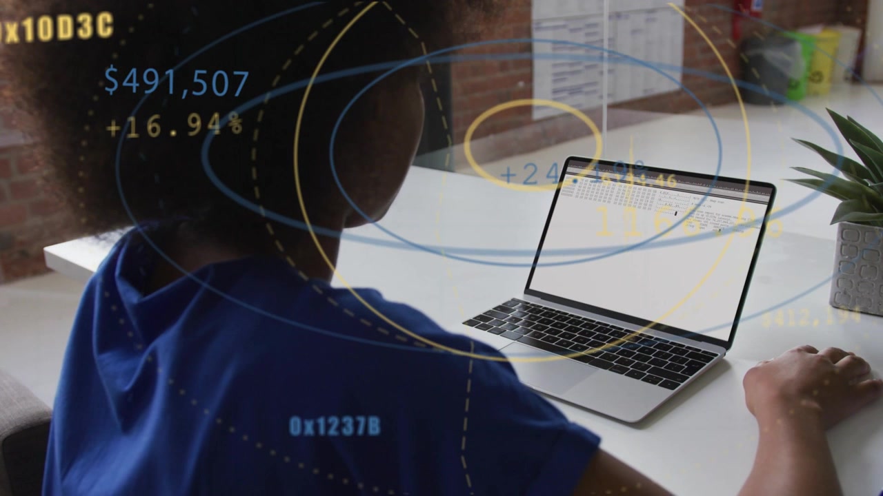 Woman at desk moving hand to laptop analyzing finance numbers and viewing yellow overlays expanding