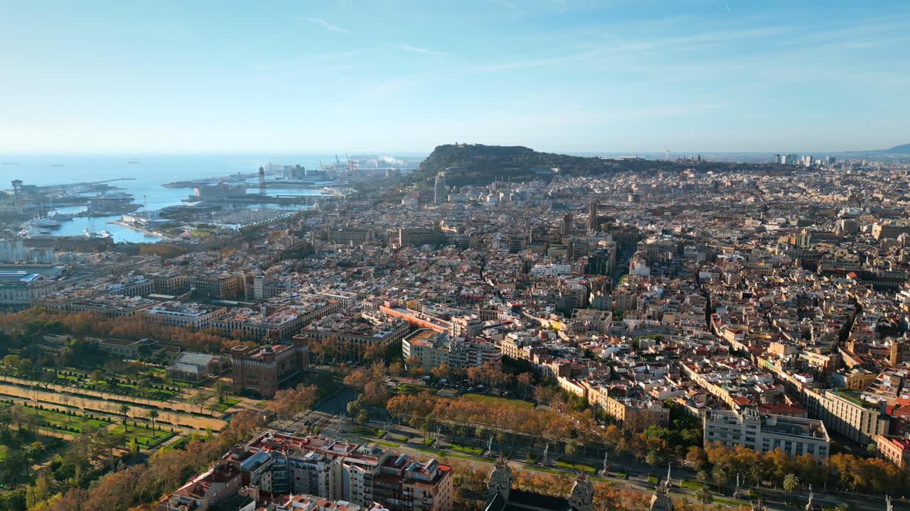 Aerial drone view of Barcelona, Spain, featuring Montjuic hill, the bustling Port of Barcelona, and the historic city center