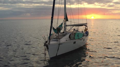 man relaxing while swinging on hammock on a sailboat during sunset in the bahamas. - aerial