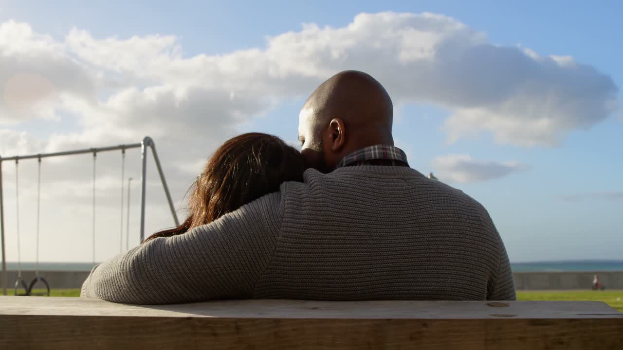 vista trasera de una pareja sentada en un banco en el parque 4k