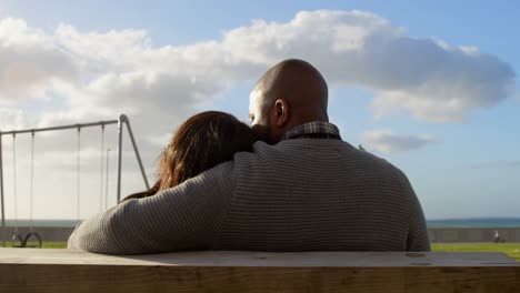rear view of couple sitting on bench in the park 4k