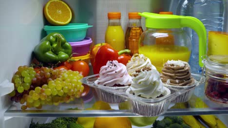 pasteles dulces en el refrigerador abierto.