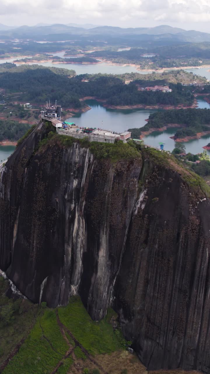 Aerial view of El Penon de Guatape, a massive rock dominating the landscape near the town of Guatape, Antioquia, Colombia. Vertical Video