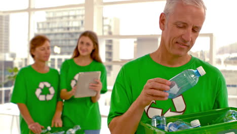 Casual-Man-holding-bottle-up-for-recycling-