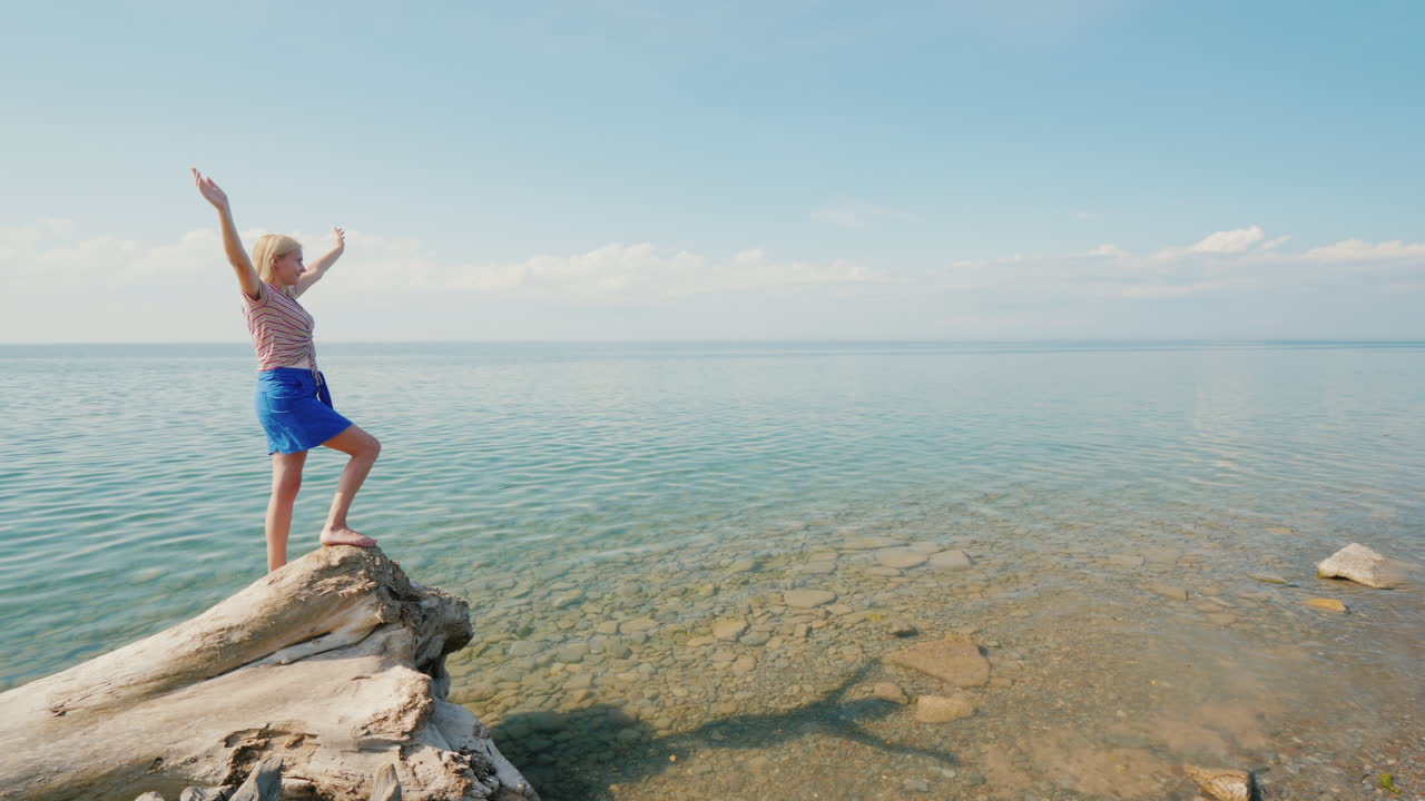 la joven se regocija en un cálido día de verano levantó las manos en un hermoso lugar en el