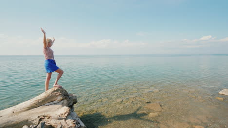la joven se regocija en un cálido día de verano levantó las manos en un hermoso lugar en el