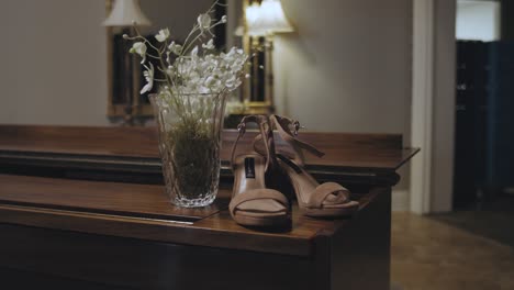 dolly shot of bridal wedding shoes bride shoes and bouqet on wedding day