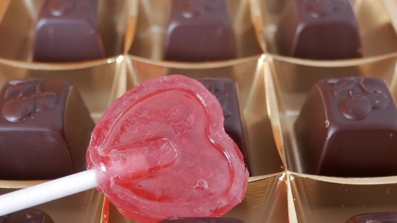 Sweet heart-shaped lollipop placed next to chocolates in a Valentine's Day setup