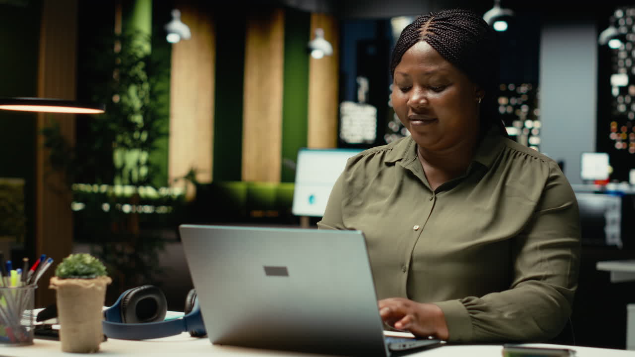 Black businesswoman typing data reports and managing information