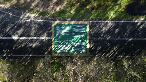 Señal-De-Precaución-En-La-Carretera-De-Gran-Tamaño-Pintada-Con-Zona-Para-Koalas,-Vista-Desde-Arriba-Con-Vehículos-Pasando