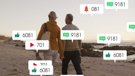 animation von social-media-text und -ikonen über einem kaukasischen paar am strand