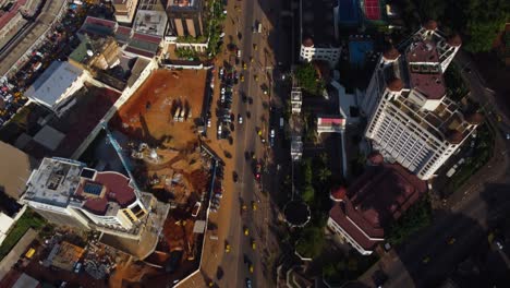 Toma-Aérea-Inclinada-Siguiendo-Los-Coches-En-El-Centro-De-Yaundé,-El-Soleado-Camerún,-África.