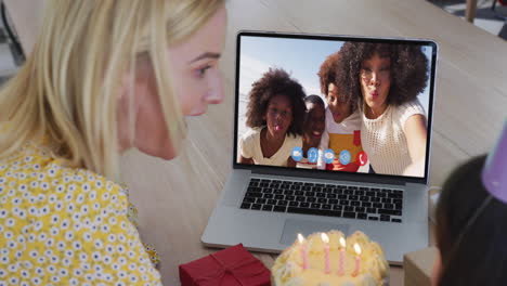 madre y hija caucásicas celebrando su cumpleaños mientras hacen una videollamada en una computadora portátil en casa