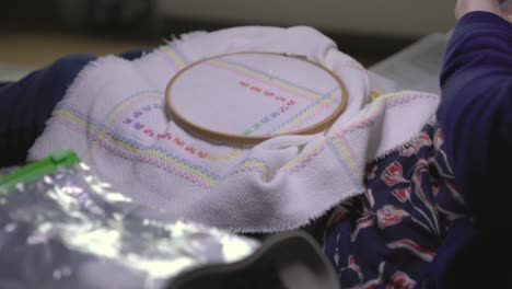 close-up shot of a needle sitting on top of a cross-stitch baby blanket