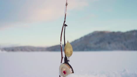 lure bait hanging on a fishing rod in snow