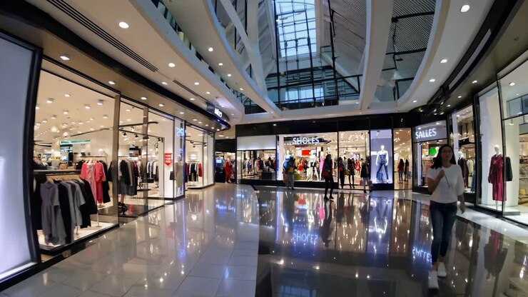 Wide-angle shot of a modern shopping mall interior with glossy floors and bright displays