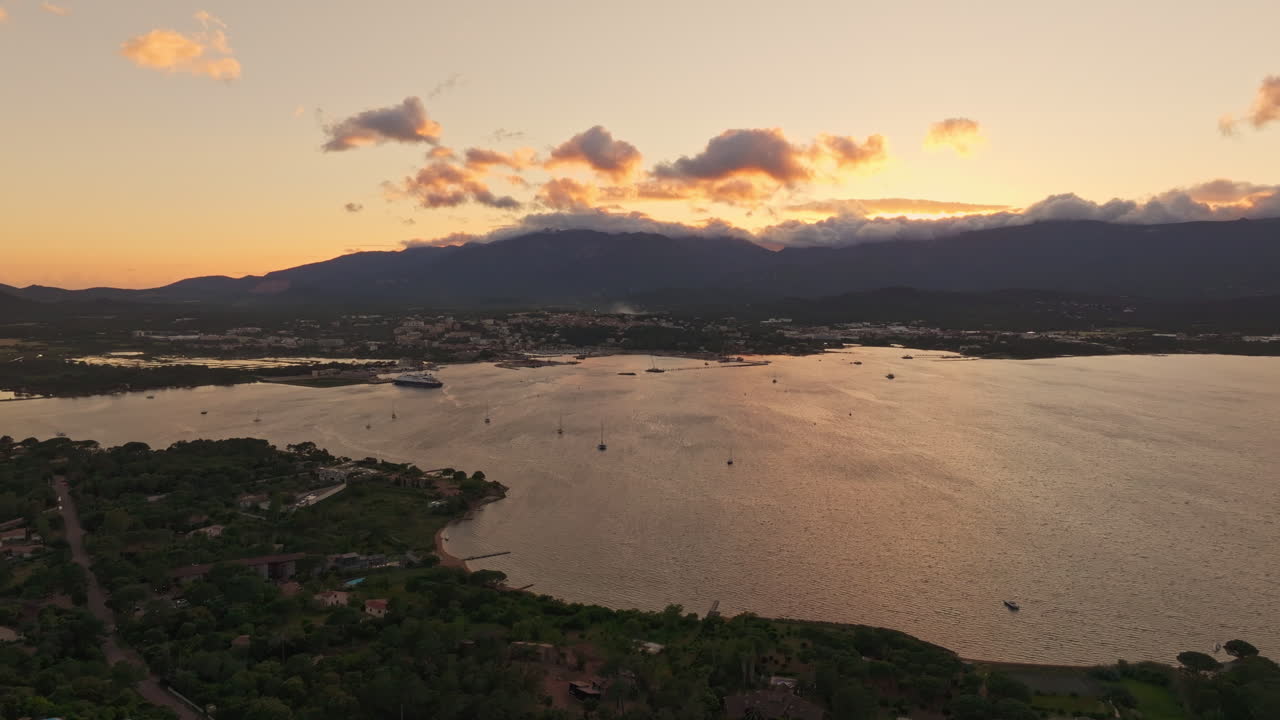 Aerial drone shot over the coastline of Porto Vecchio, southern Corsica, France. Golden hour sunset, warm colorful sky