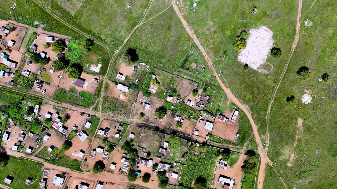 Overhead aerial view of informal settlement built on farming village outskirts