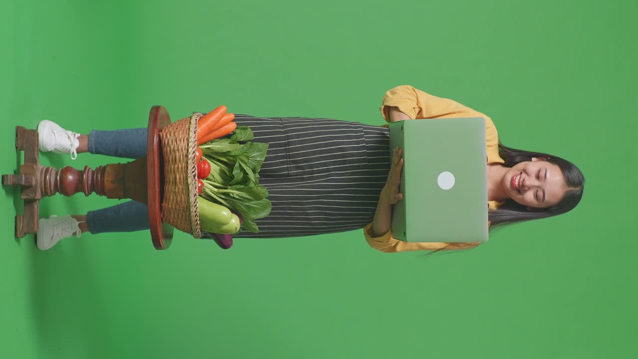 mujer con computadora portátil y verduras en pantalla verde
