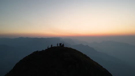 aerial drone shot of kolukkumalai range with early morning mist embracing the hills