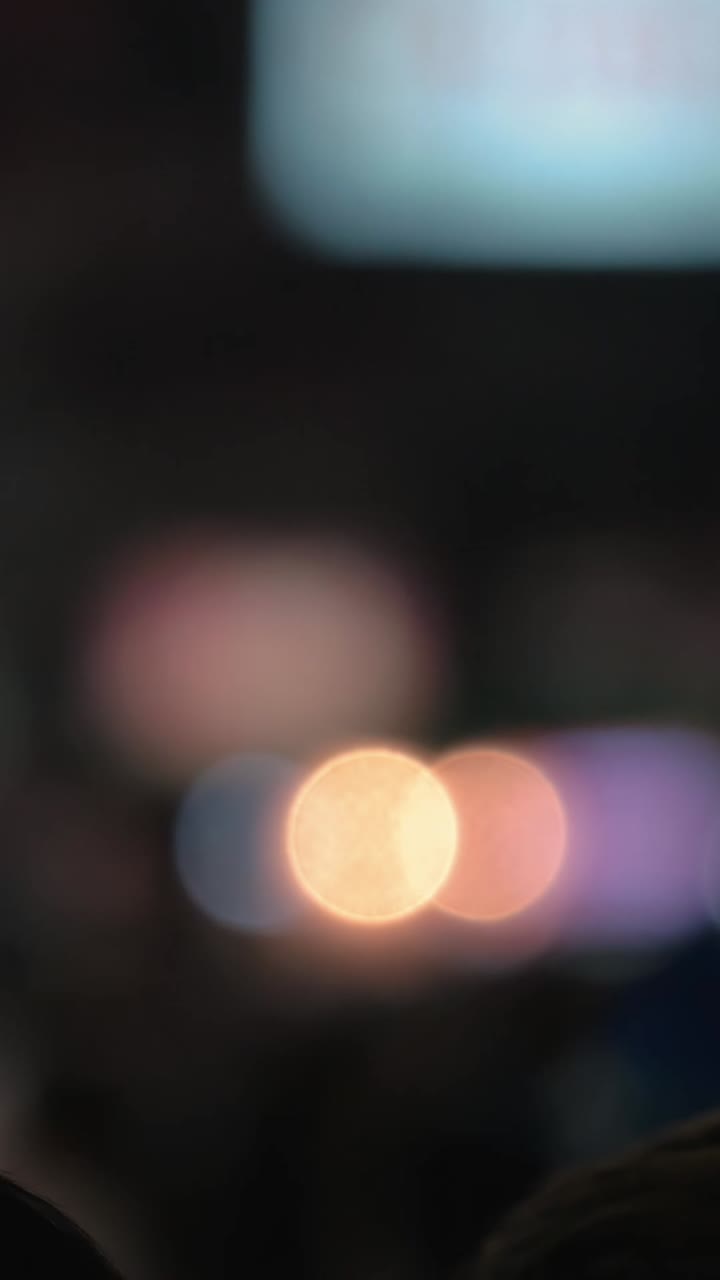 Abstrakte bokeh-lys i bevægelse på mørk baggrund.