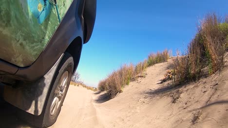 Truck-Wheel-Driving-through-grassy-sand-dunes